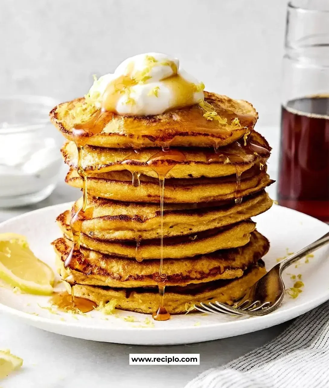 Delicious lemon ricotta protein pancakes served on a plate with fresh lemon slices.