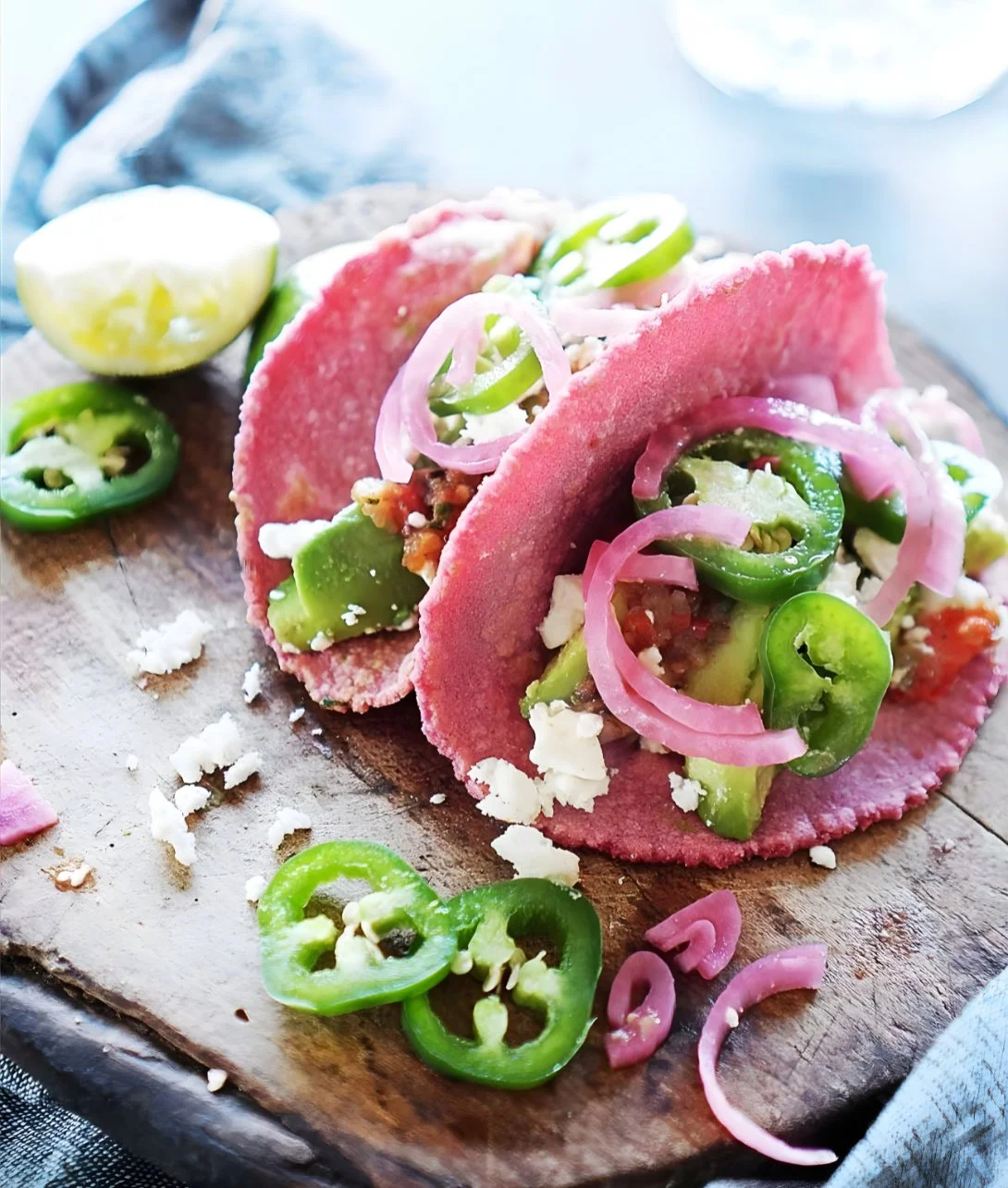 Homemade corn tortillas stacked on a wooden table for tacos and enchiladas.