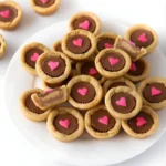 Delicious Valentine's Cookie Cups filled with frosting and heart sprinkles