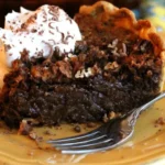 Homemade German Chocolate Pie topped with coconut and pecan filling