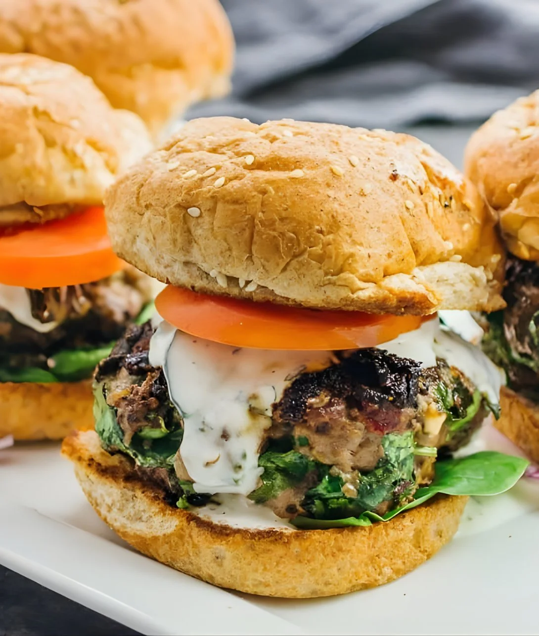 Delicious Greek burgers topped with feta cheese and fresh ingredients