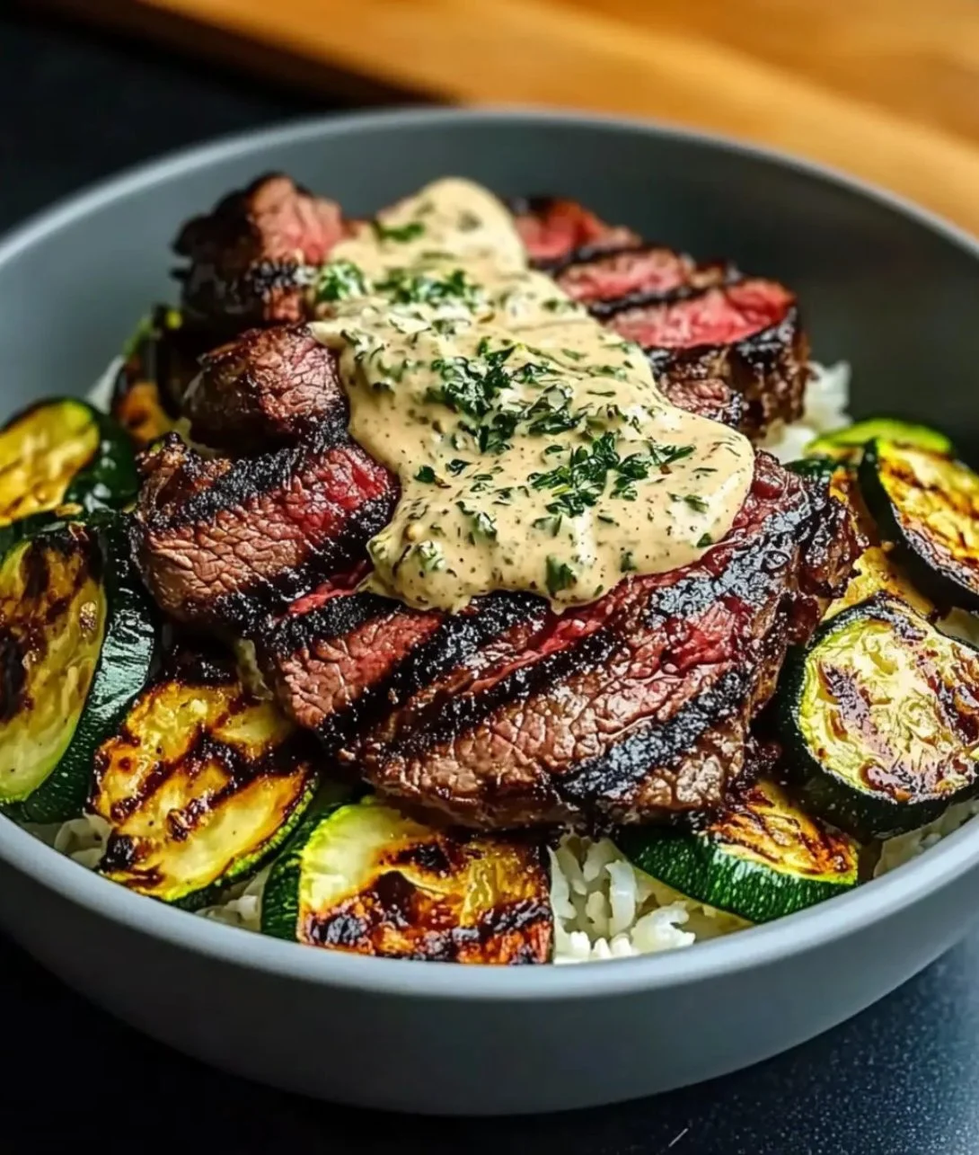 Grilled steak bowl with fresh veggies and sauce.