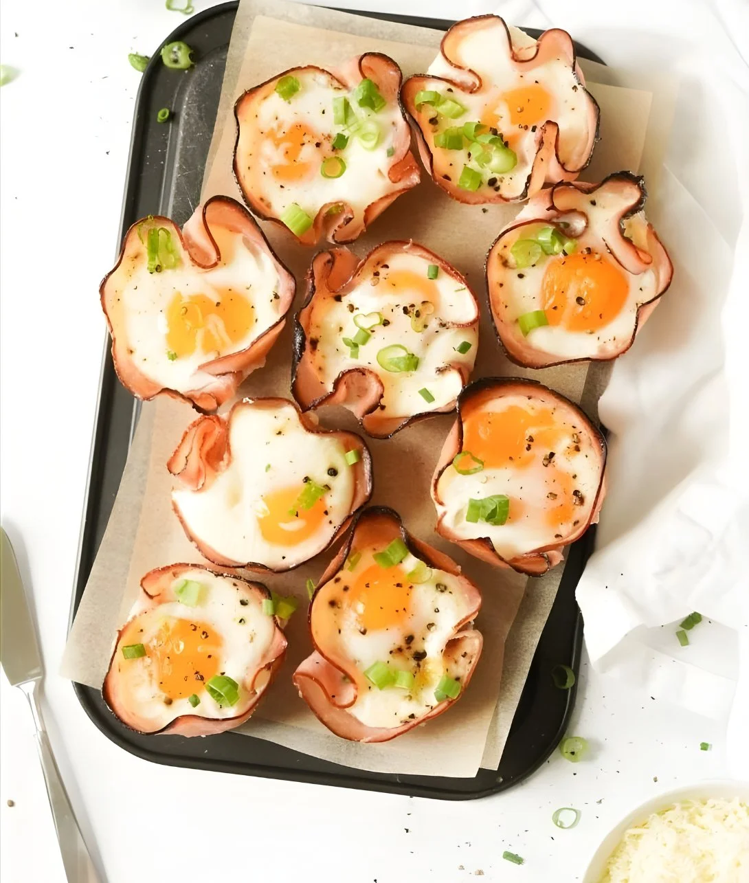 Baked ham and cheese egg cups served on a plate for breakfast