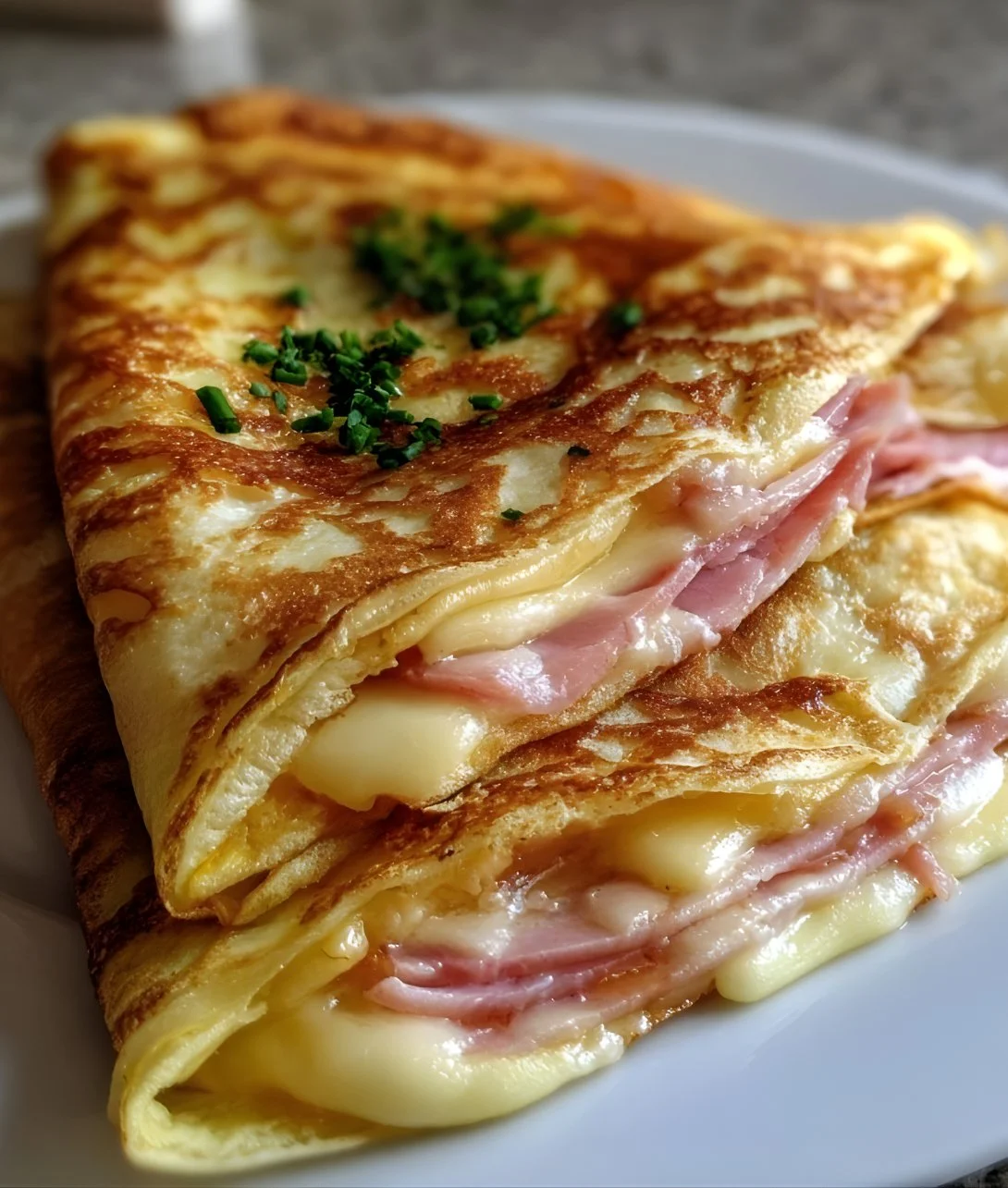 Savory ham cheese crêpes plated with herbs and spices