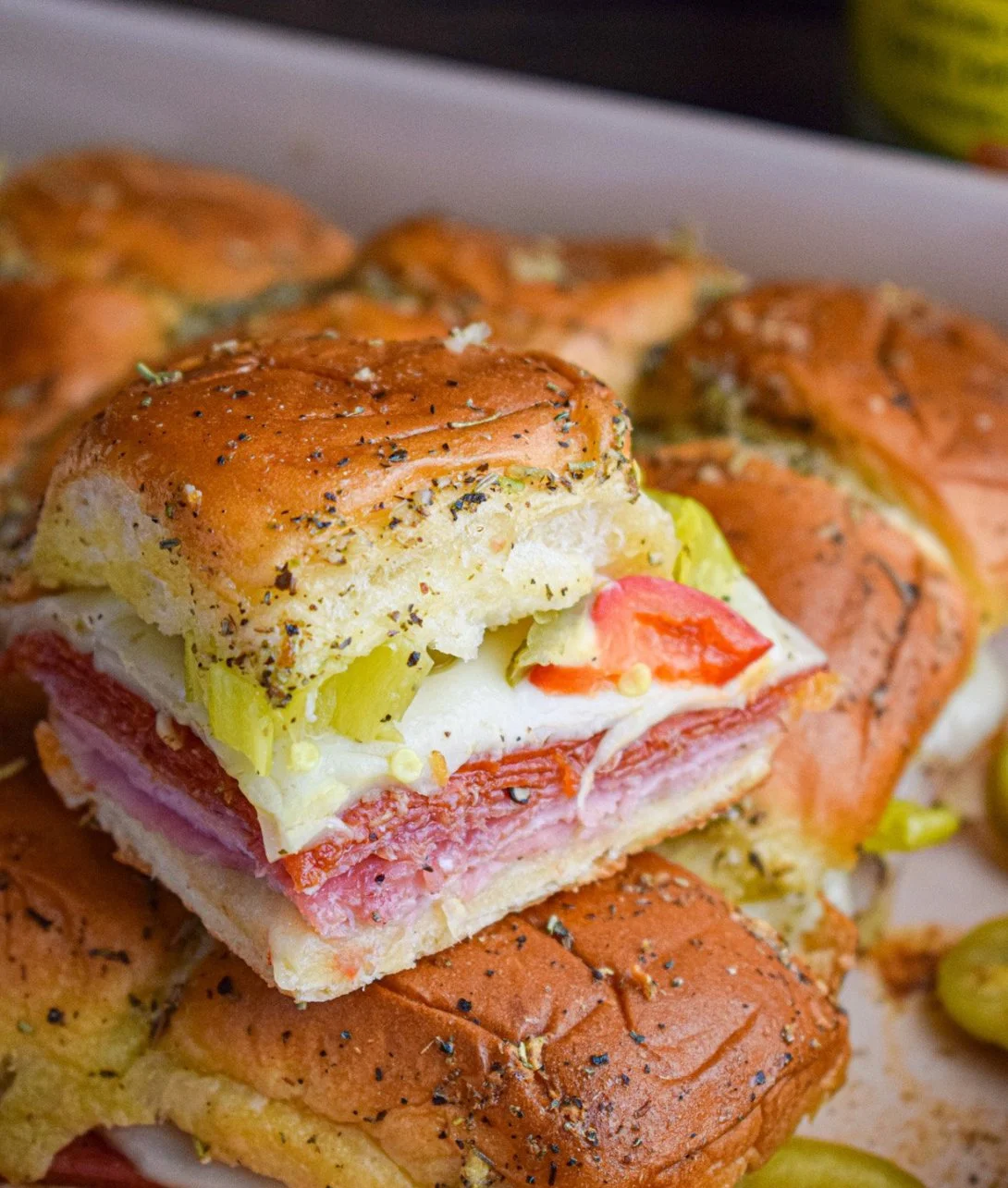 Hot Italian sub sliders served with fresh ingredients and melted cheese