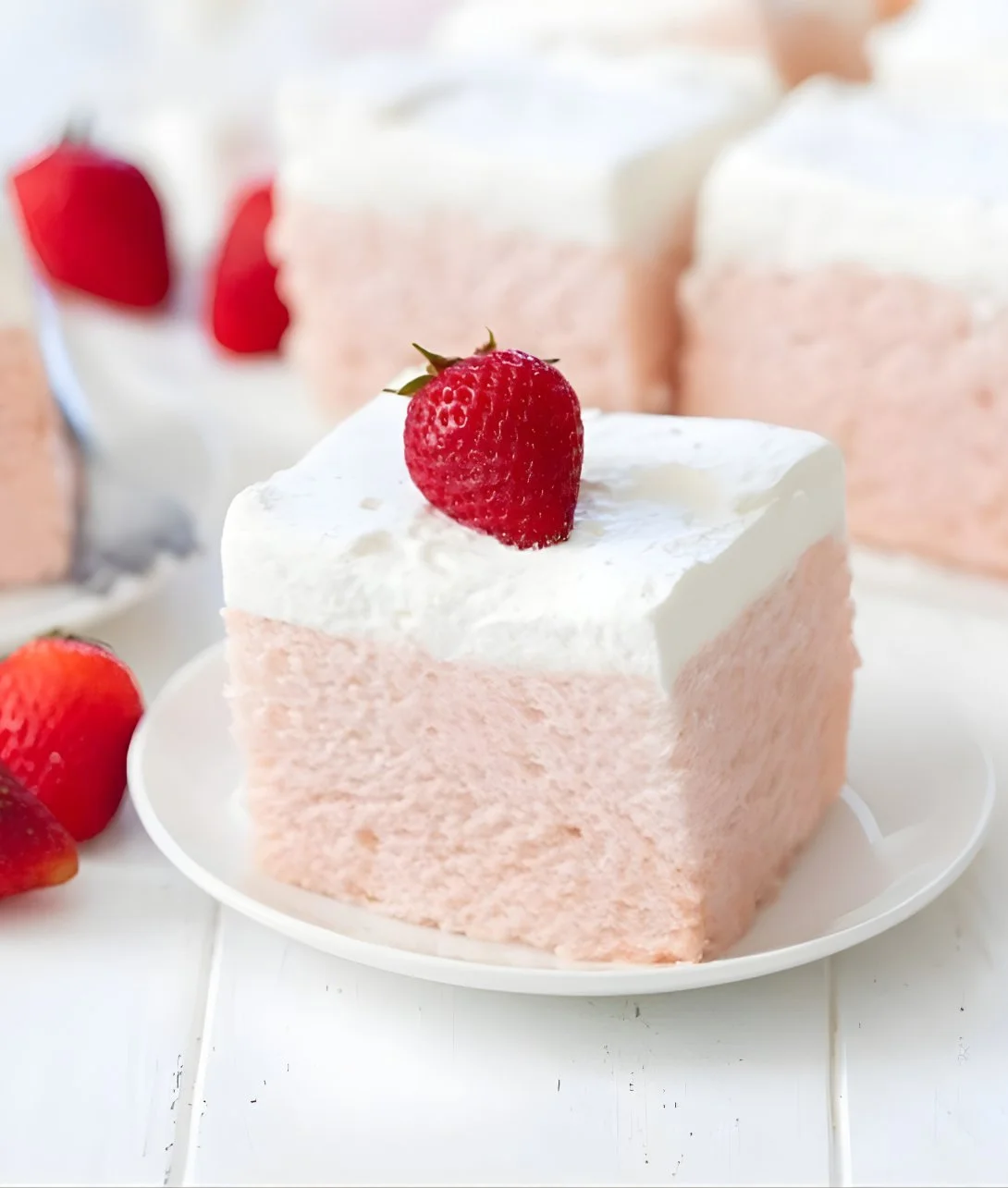 No Bake Strawberry Cloud Cake garnished with fresh strawberries