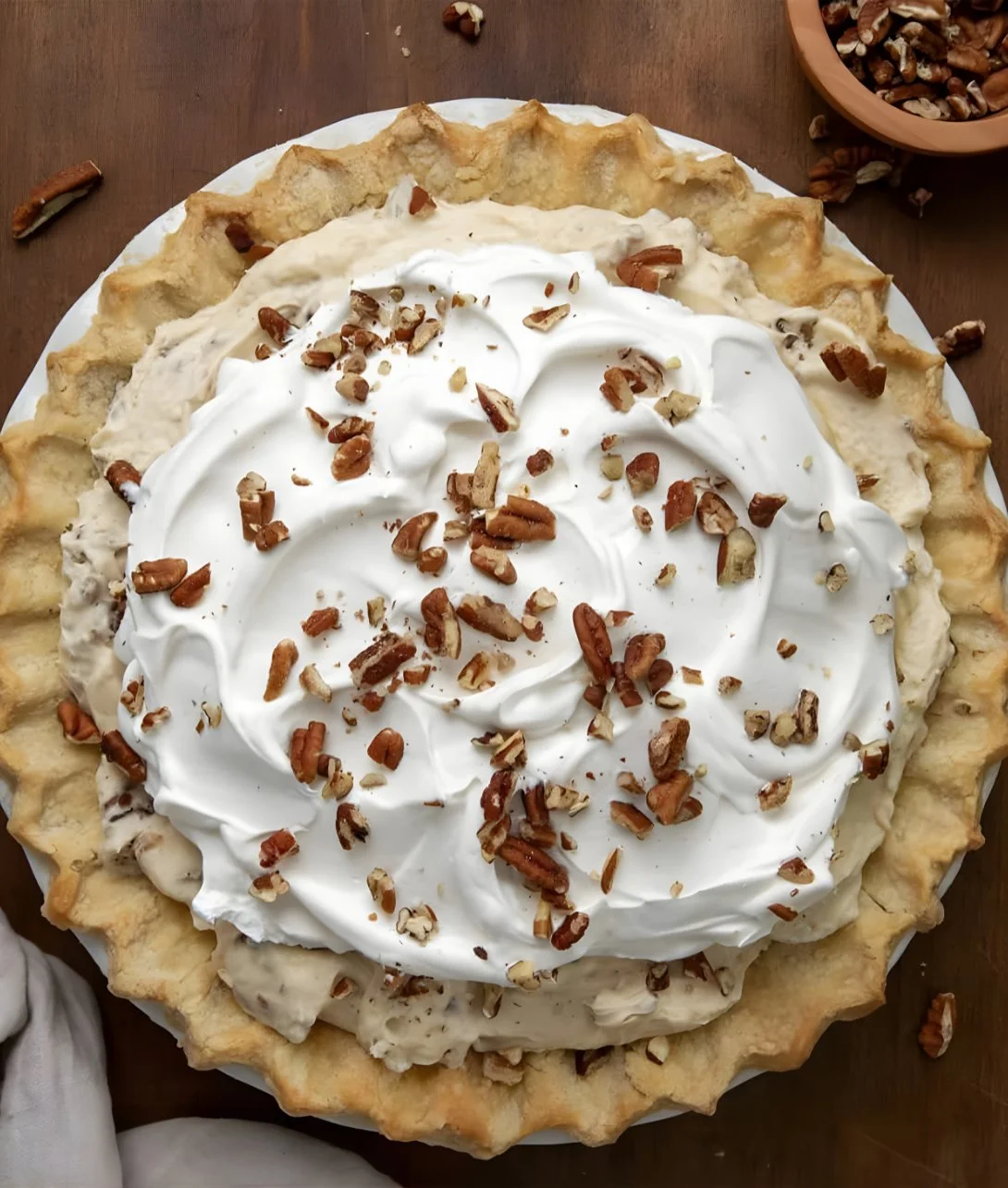 Delicious Pecan Cream Pie topped with nuts and whipped cream