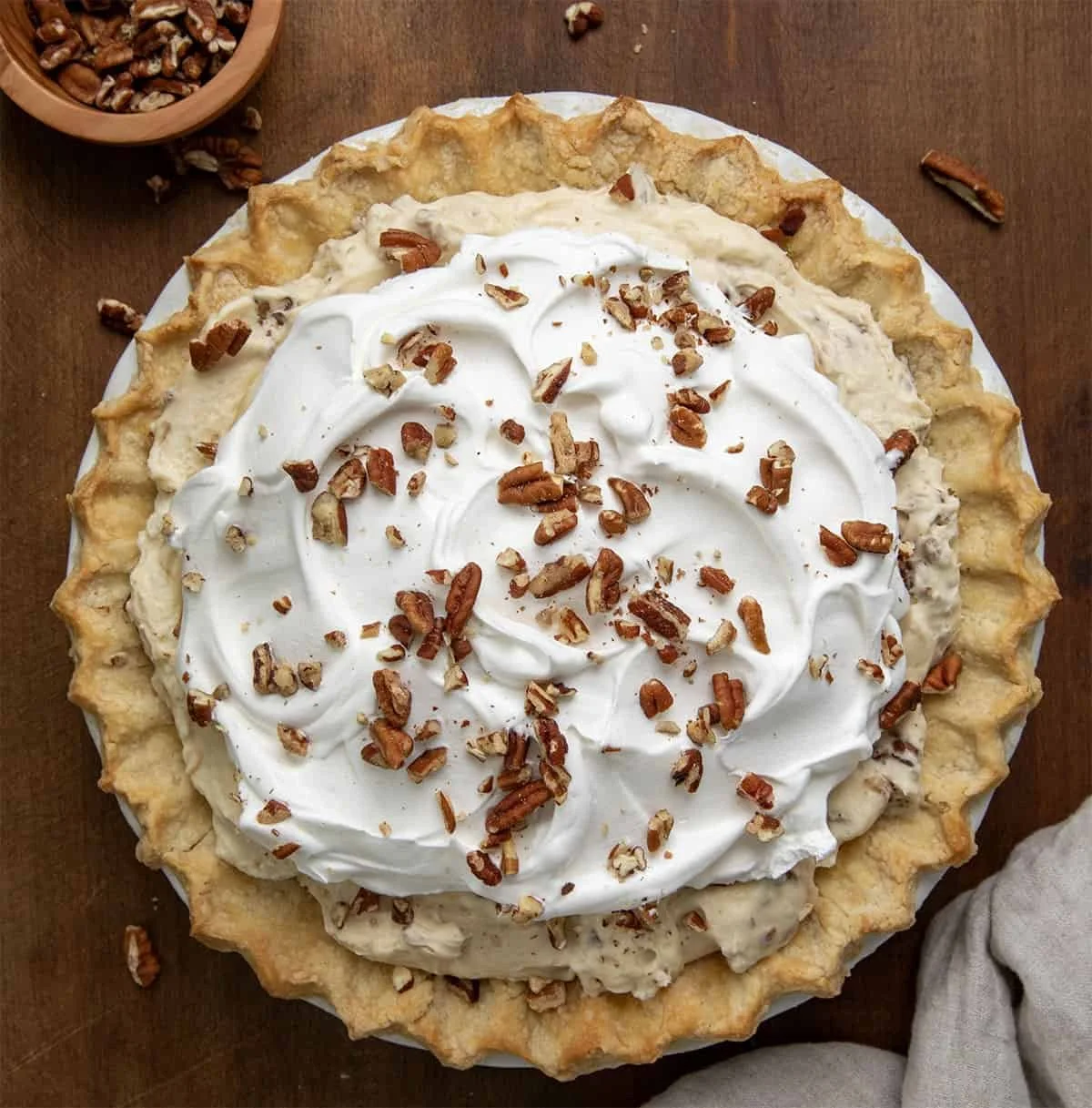 Delicious pecan cream pie topped with whipped cream and pecans