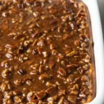 Delicious pecan pie cheesecake topped with caramelized pecans and whipped cream