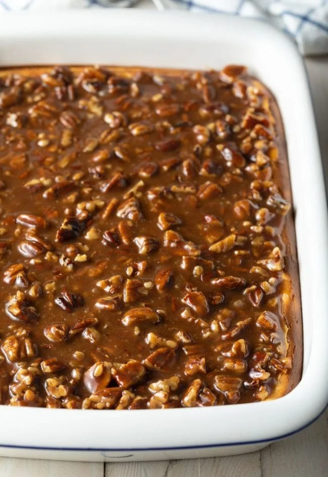 Delicious pecan pie cheesecake topped with caramelized pecans and whipped cream