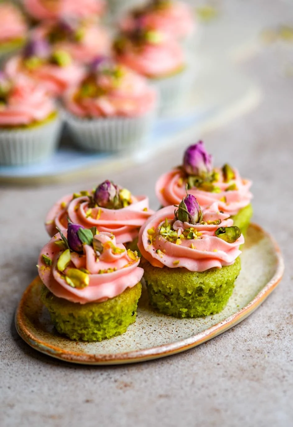 Vegan Mini Rose Pistachio Cupcakes with decorative frosting and pistachio topping