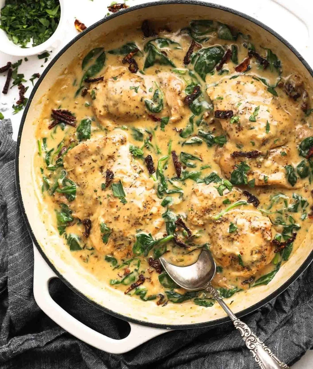 25-Minute dairy-free creamy Tuscan chicken dish served on a plate with herbs.