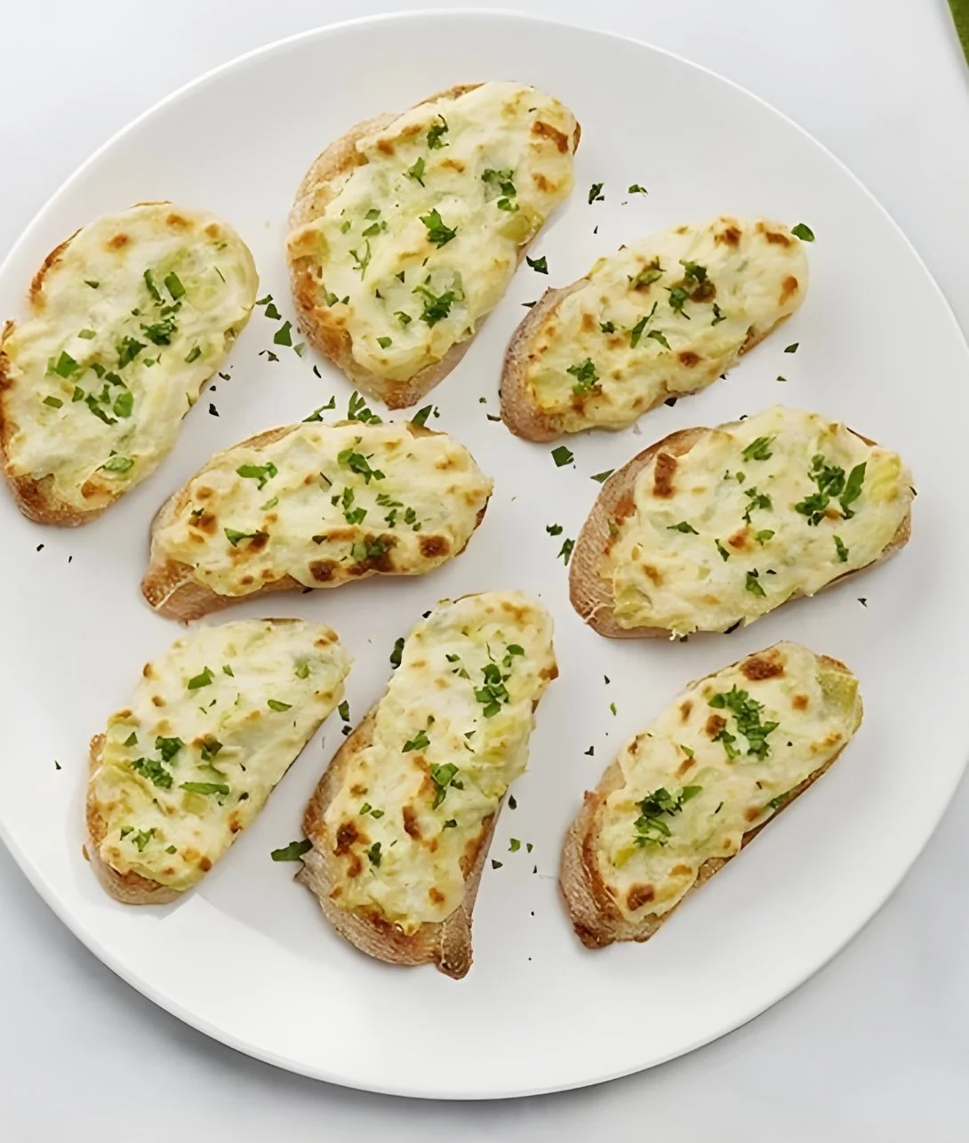 Delicious Artichoke Bruschetta topped with fresh herbs and served on crispy bread.