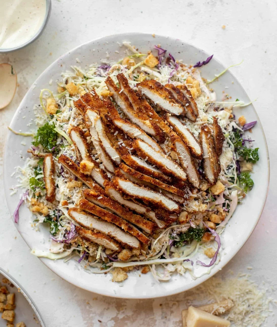 Delicious Caesar Slaw topped with crispy chicken and fresh ingredients