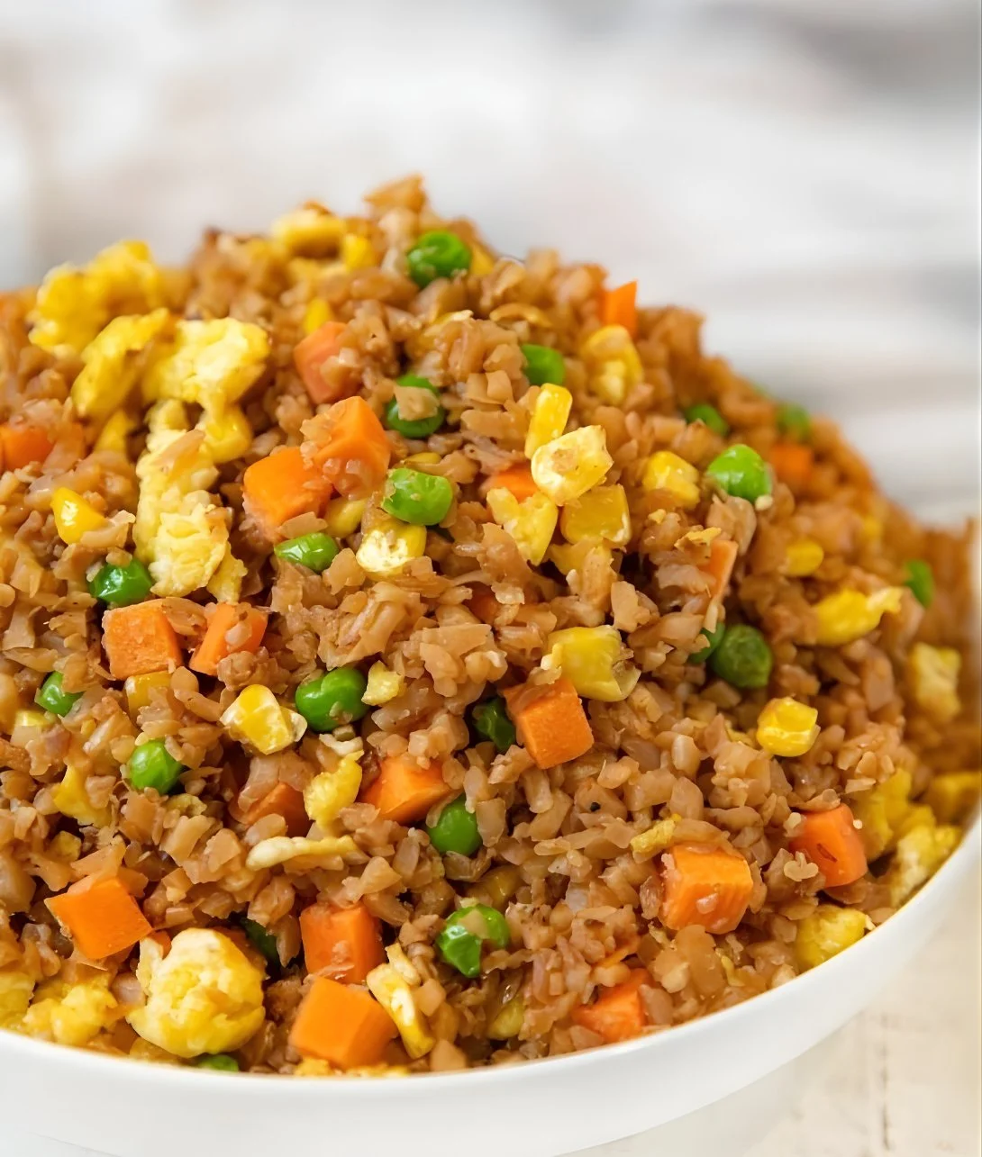 Delicious Cauliflower Egg Fried Rice in a bowl with vegetables and eggs