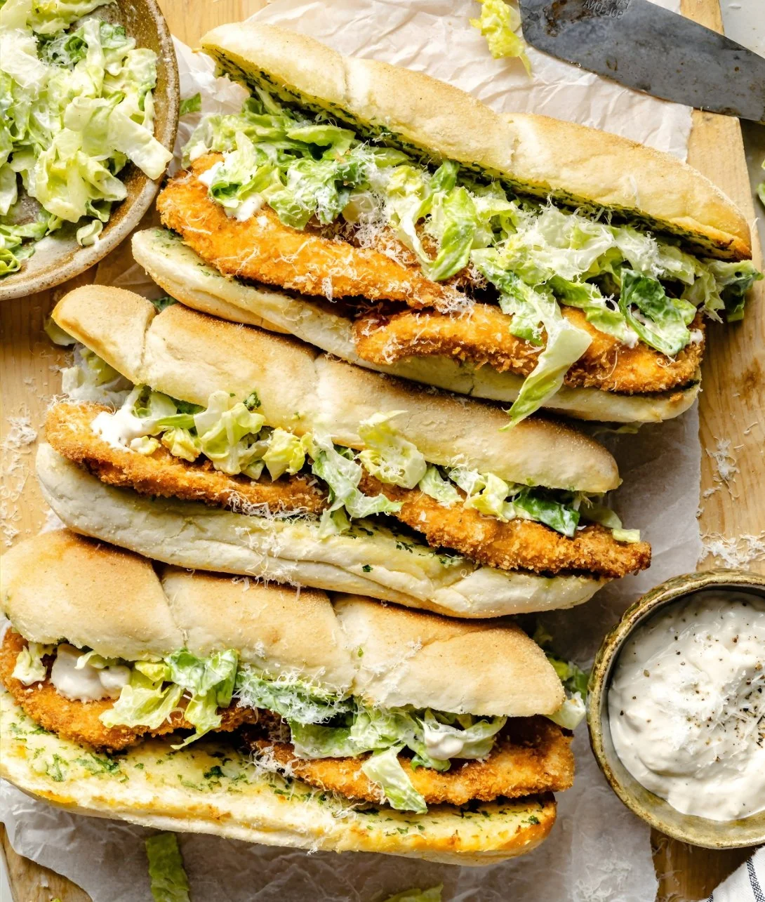 Close-up of a Chicken Caesar Sandwich with lettuce and dressing on a bun