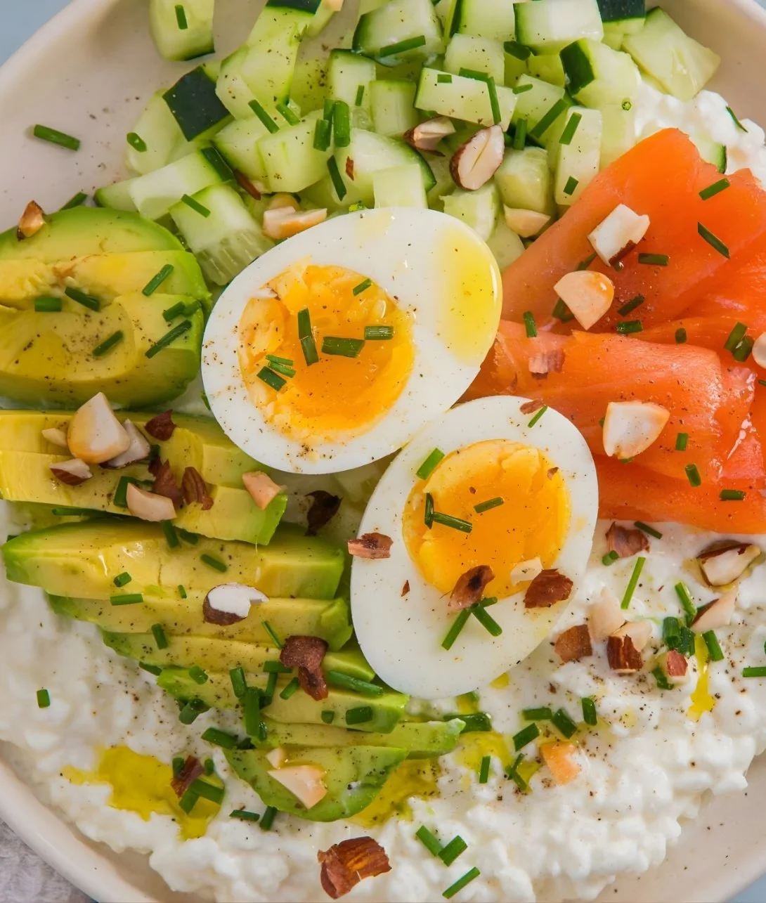 Cottage cheese salad topped with smoked salmon and avocado in a bowl