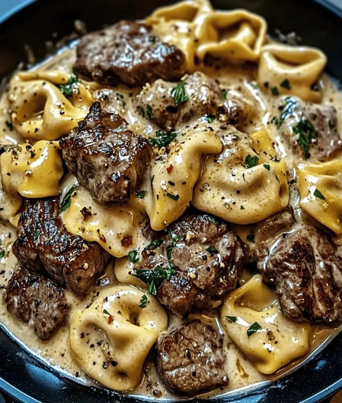 Delicious Cracked Garlic Steak Tortellini served with fresh herbs