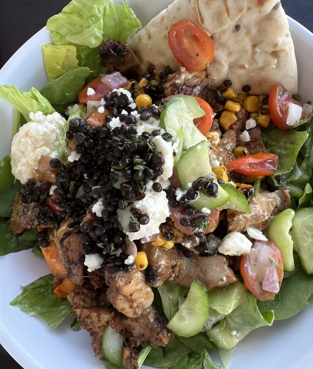 Bowl of crazy feta dip with fresh herbs and pita bread