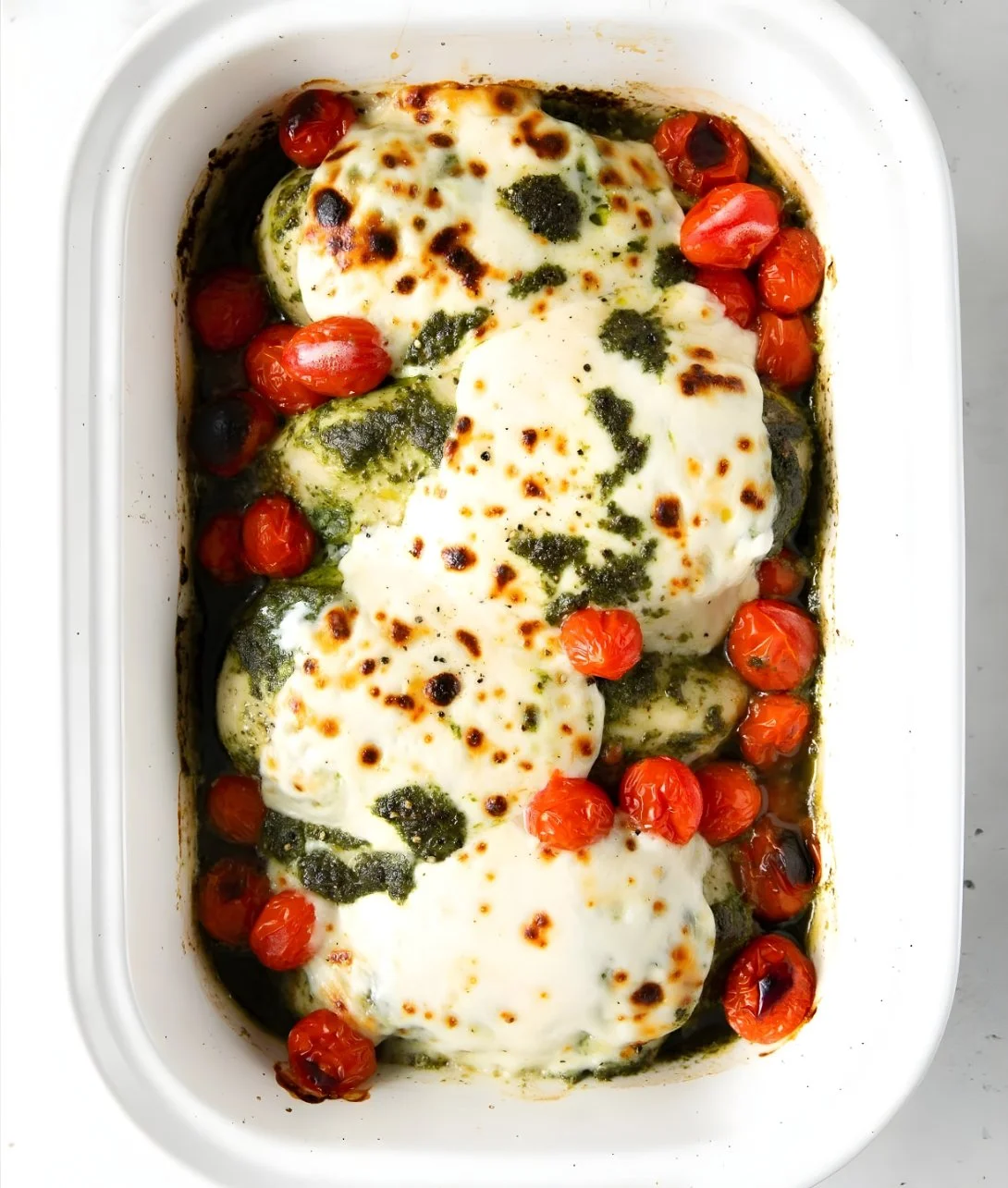 Easy baked pesto mozzarella chicken dish with fresh herbs and cheese