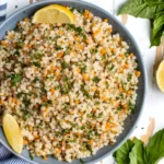 Delicious Lemon Butter Pearl Couscous served in a bowl with fresh herbs.