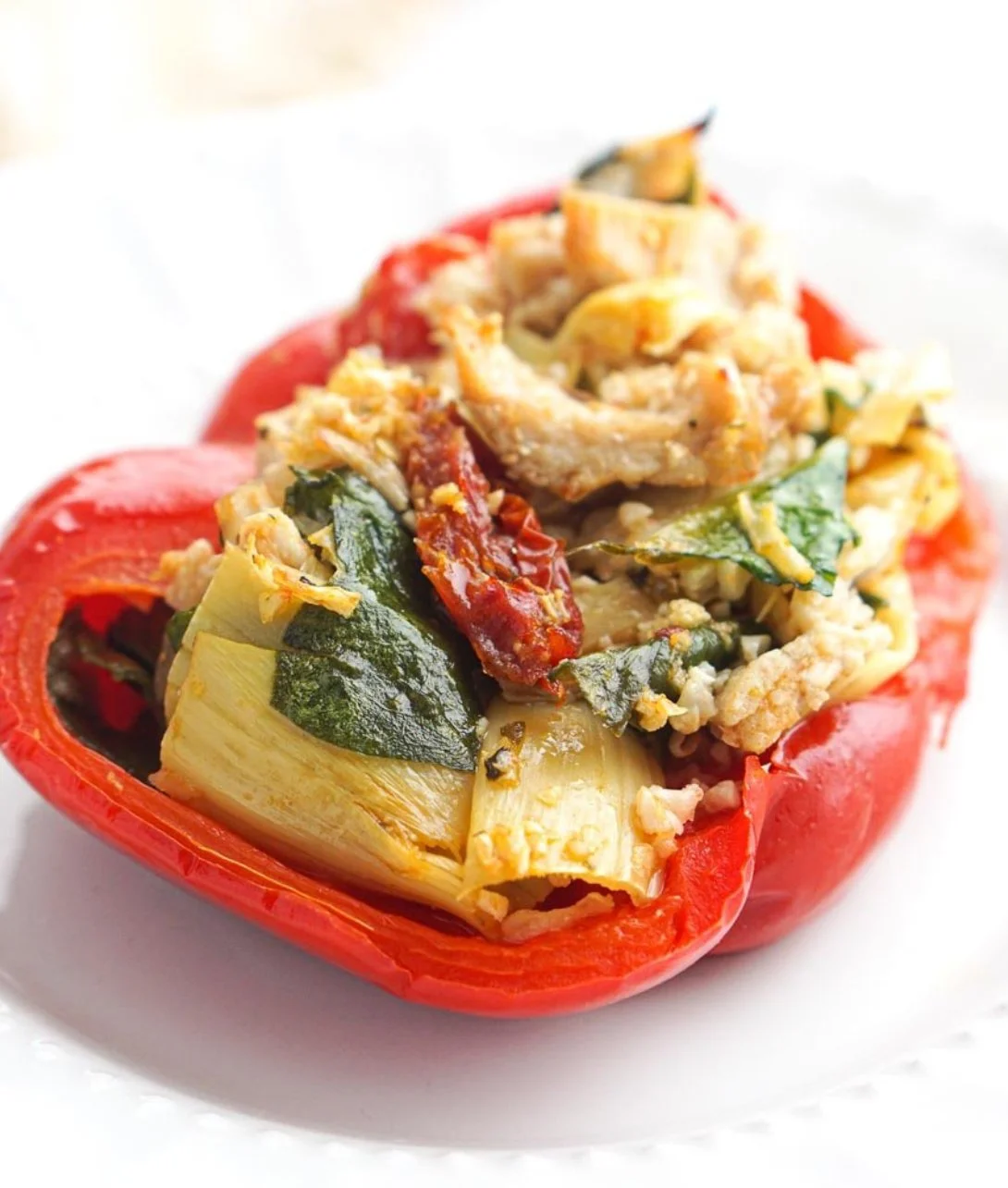 Mediterranean chicken stuffed bell peppers on a wooden table