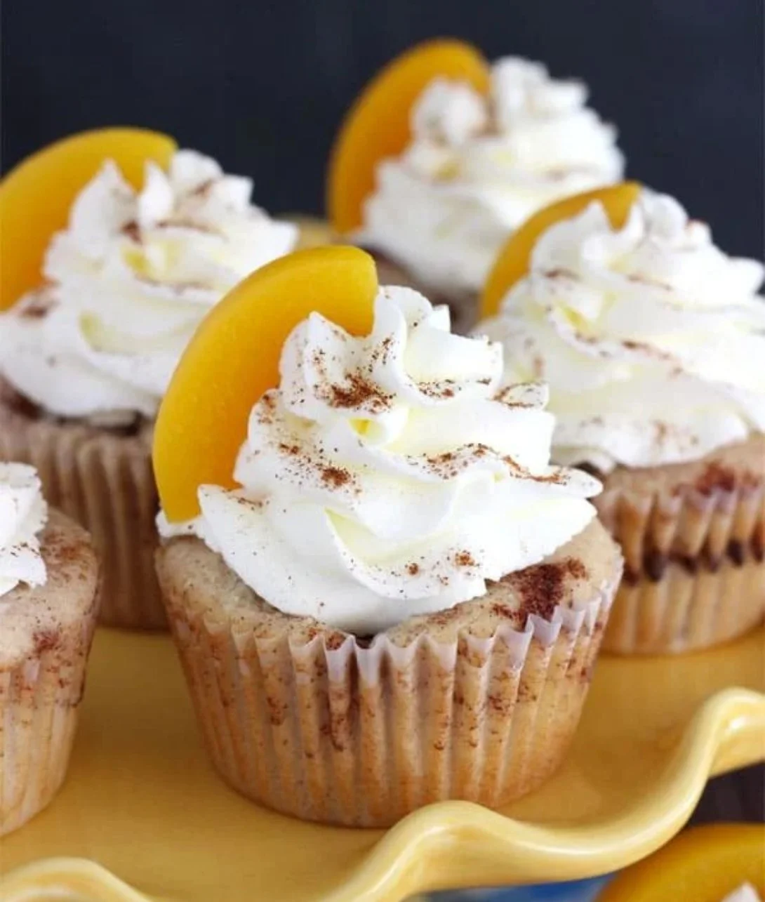 Delicious Peach Cobbler Cupcakes topped with peach filling and crumb topping.