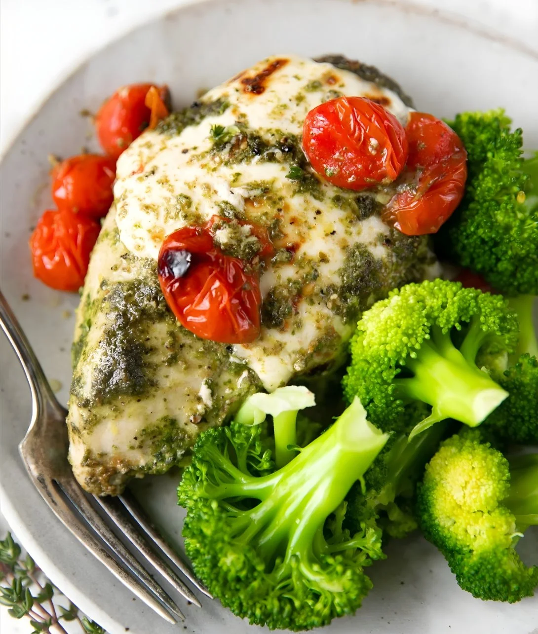 Pesto Chicken Bake garnished with fresh basil and served in a baking dish