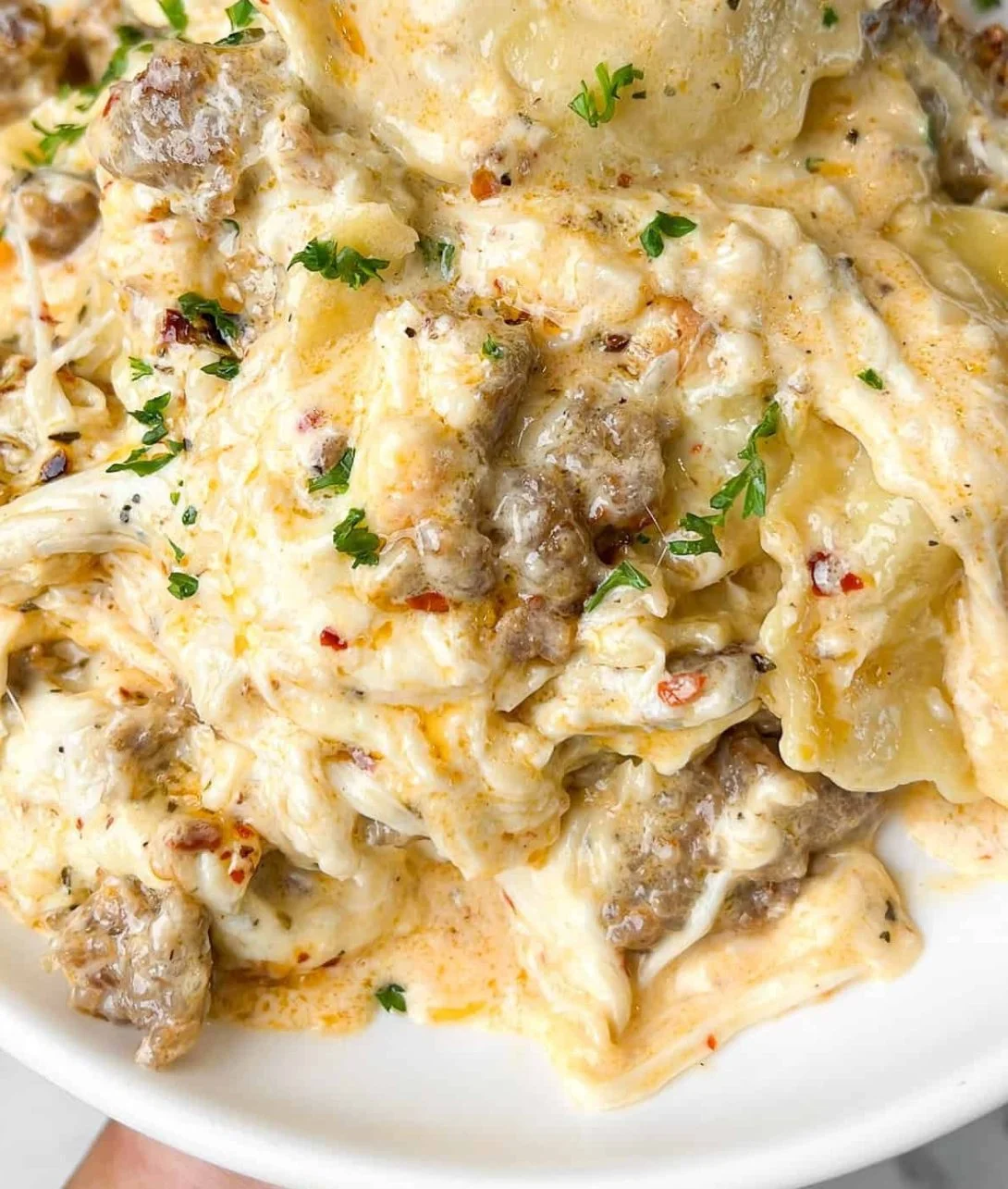 Delicious Sausage Alfredo Ravioli Lasagna layered with creamy sauce and cheese