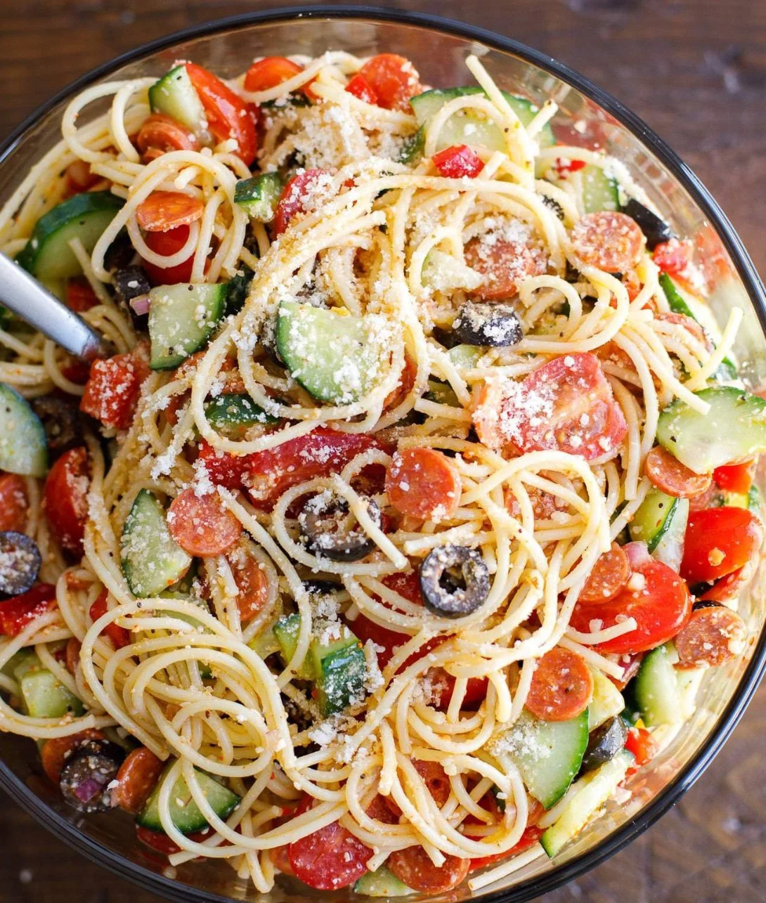 Colorful spaghetti salad with fresh vegetables and dressing