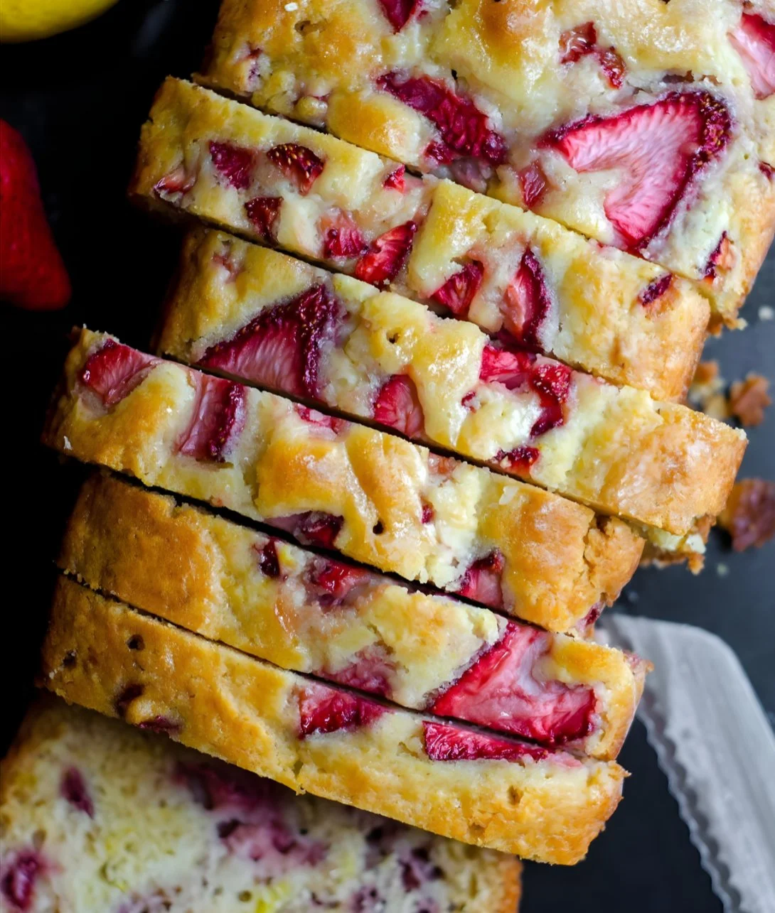 Delicious slice of strawberry lemonade quick bread with a fresh strawberry garnish