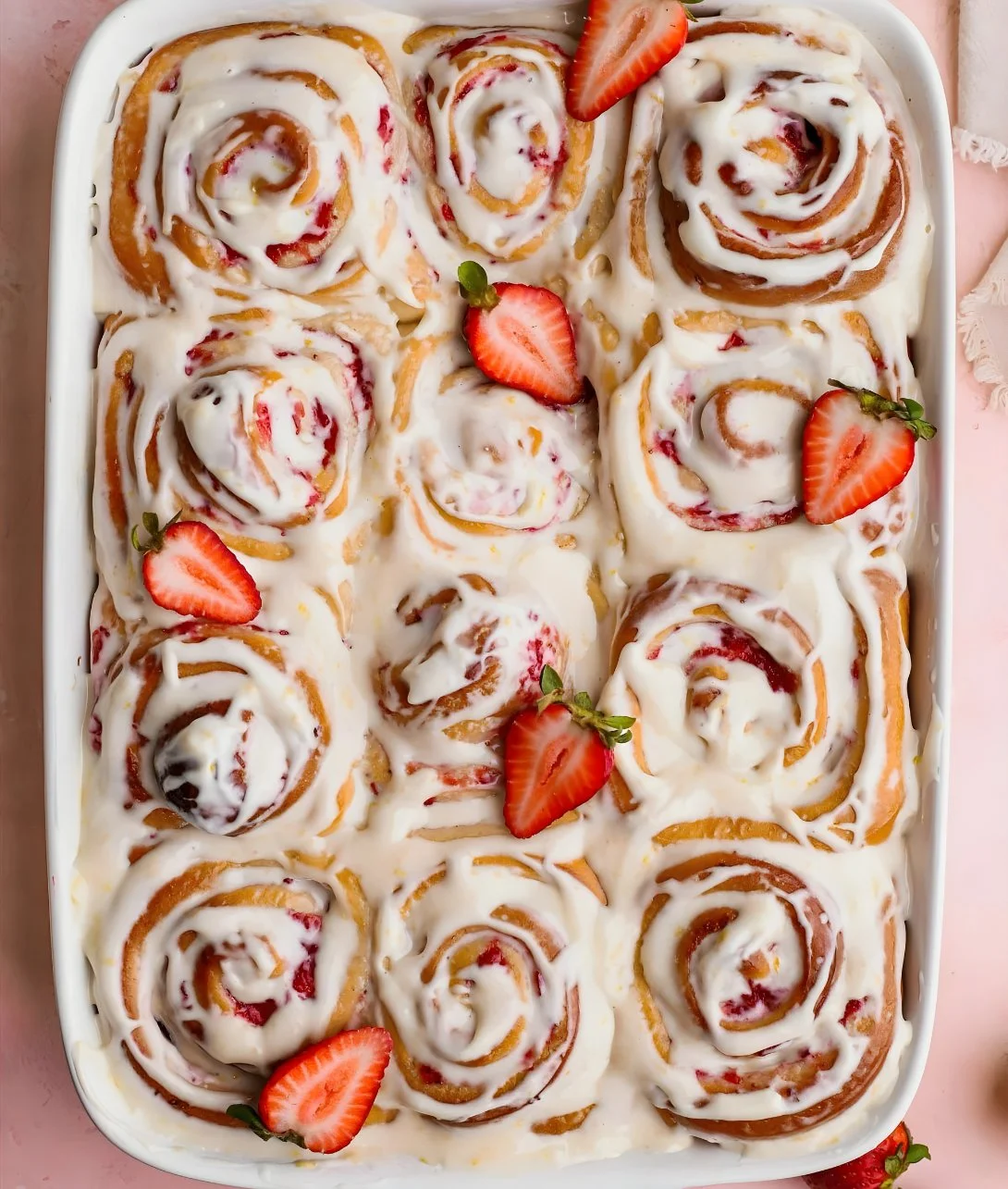 Strawberry rolls topped with lemon icing on a white plate