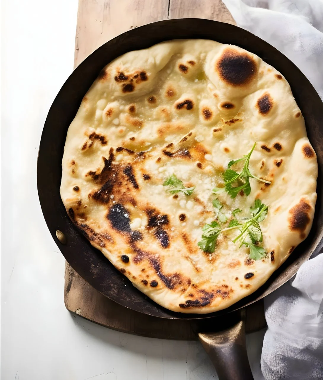Freshly baked garlic naan bread served on a plate