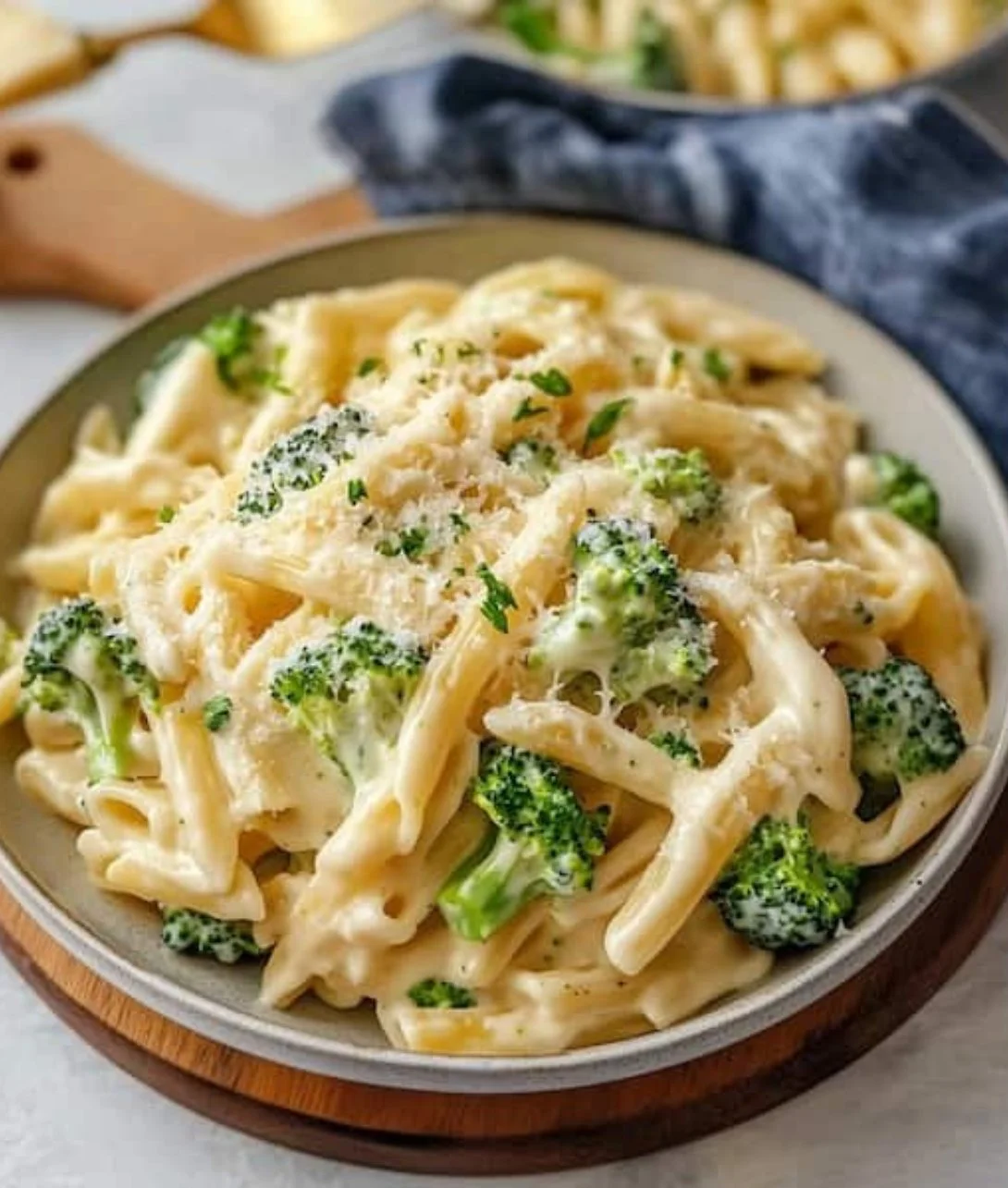 Bowl of creamy broccoli cheese pasta garnished with fresh herbs