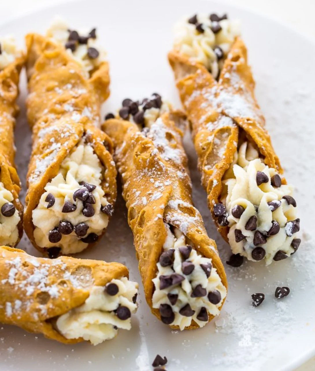 Delicious cannoli filled with ricotta cream and topped with chocolate chips.
