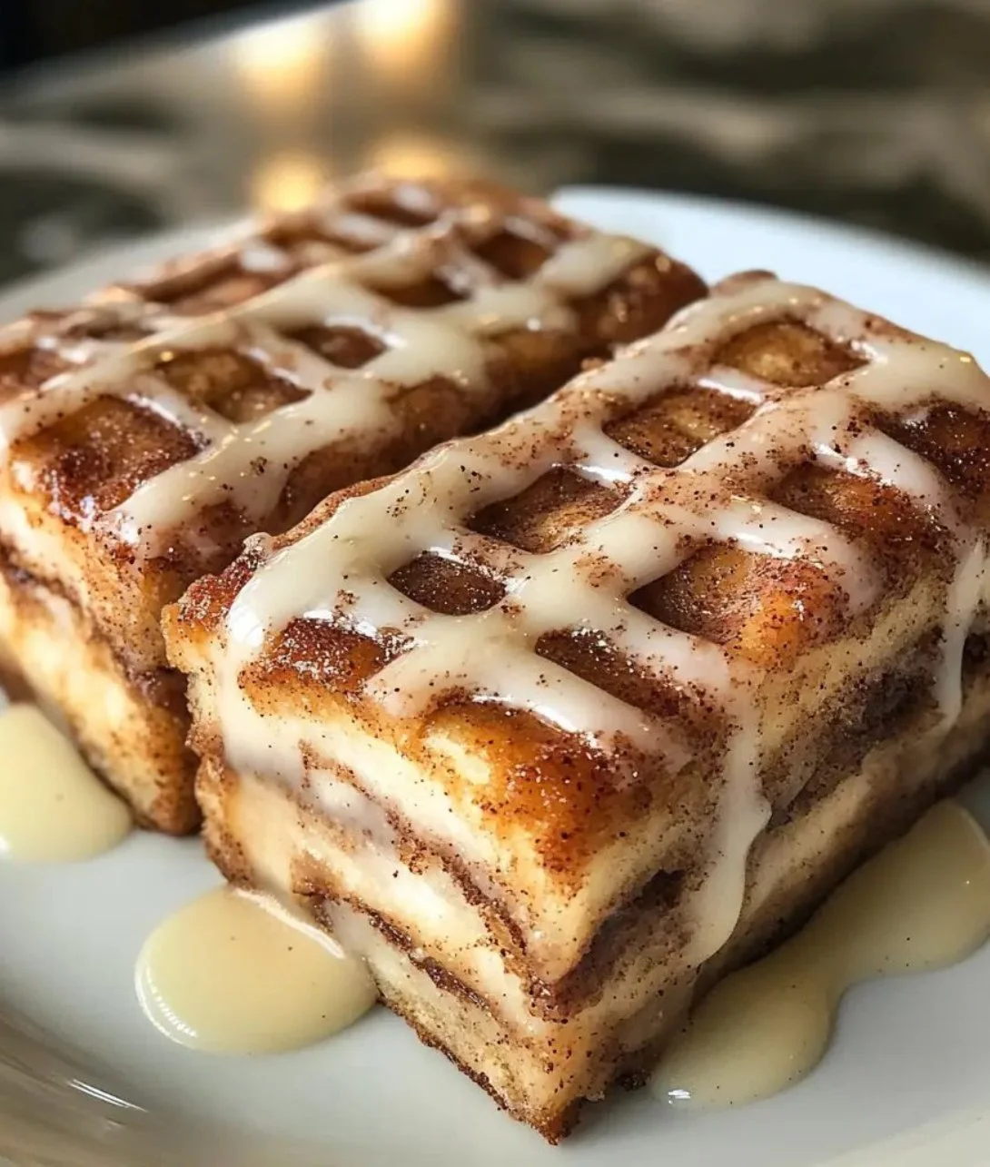 Delicious Cinnamon Roll Bliss Bars drizzled with icing on a wooden platter.