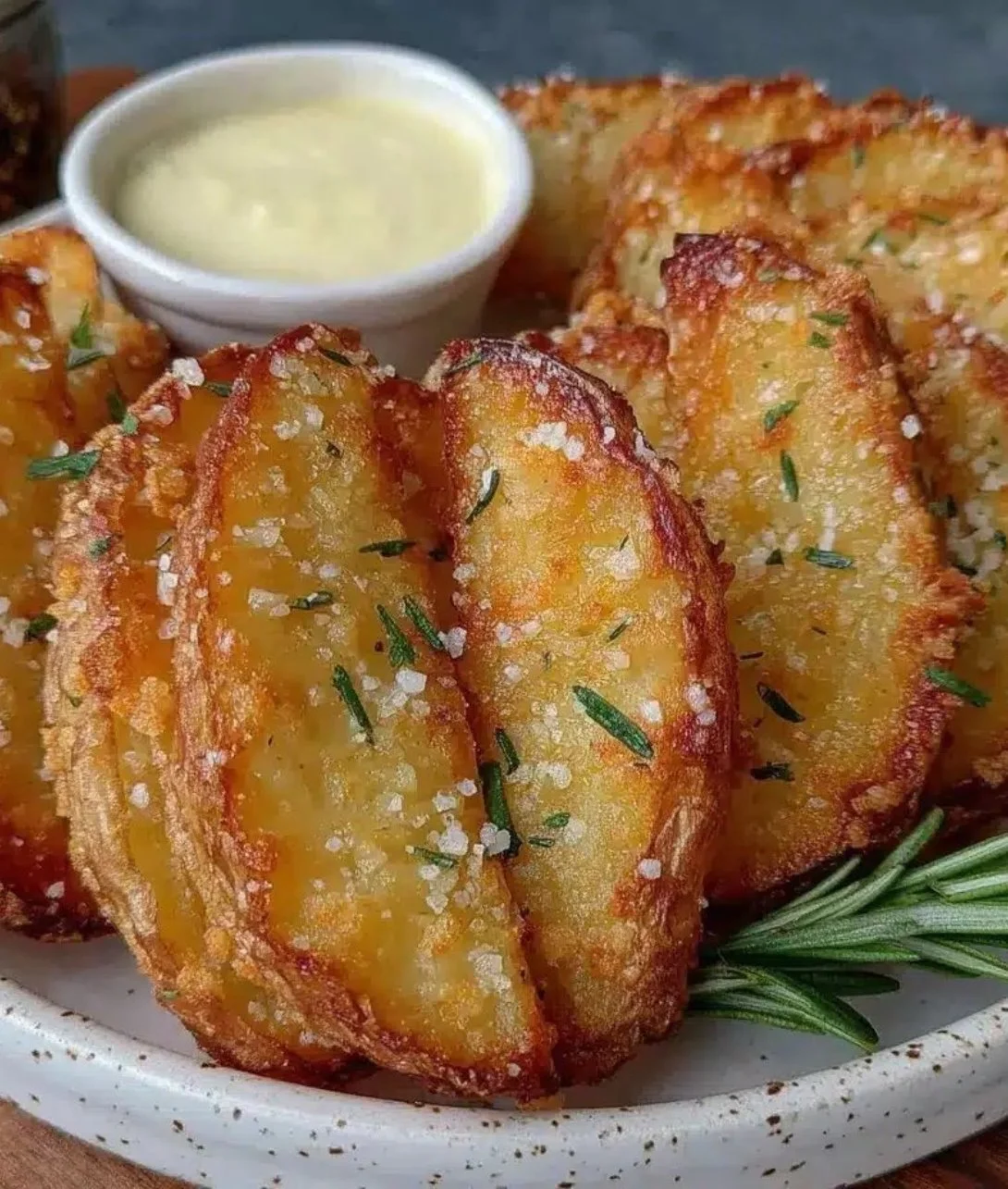 Crispy air fryer potato wedges served on a plate with dipping sauce.