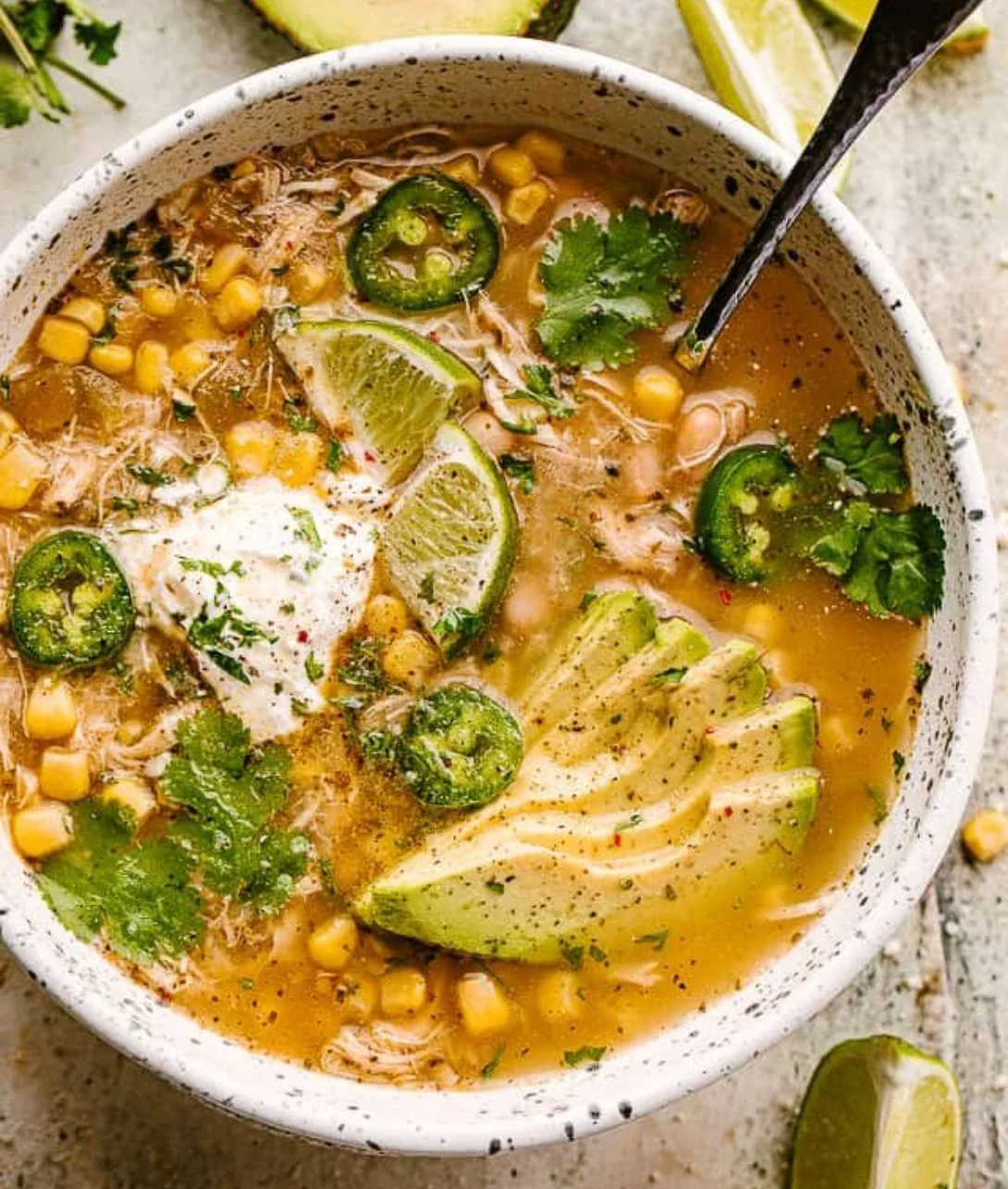 A bowl of creamy Crock Pot White Chicken Chili topped with fresh herbs
