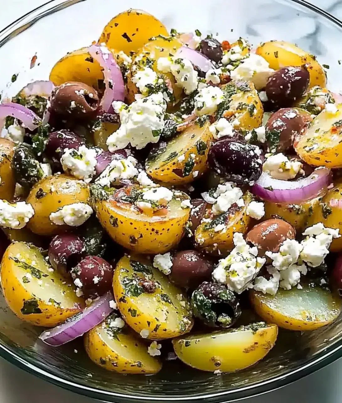 Delicious Olive Greek Potato Salad served in a bowl with fresh herbs and olives