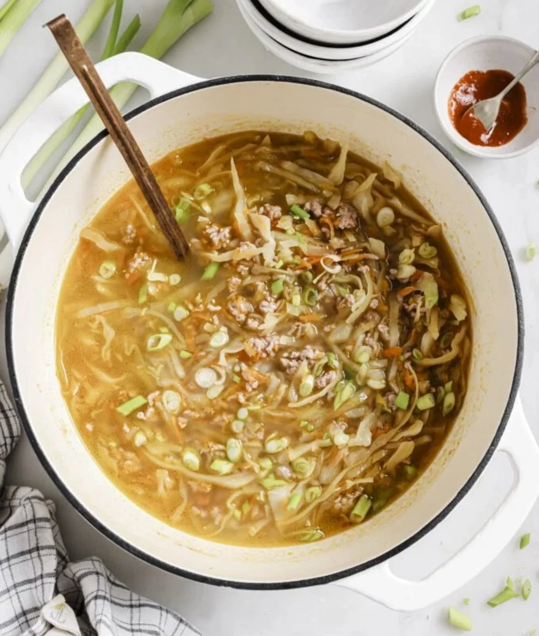 Delicious homemade easy egg roll soup in a bowl with fresh toppings.