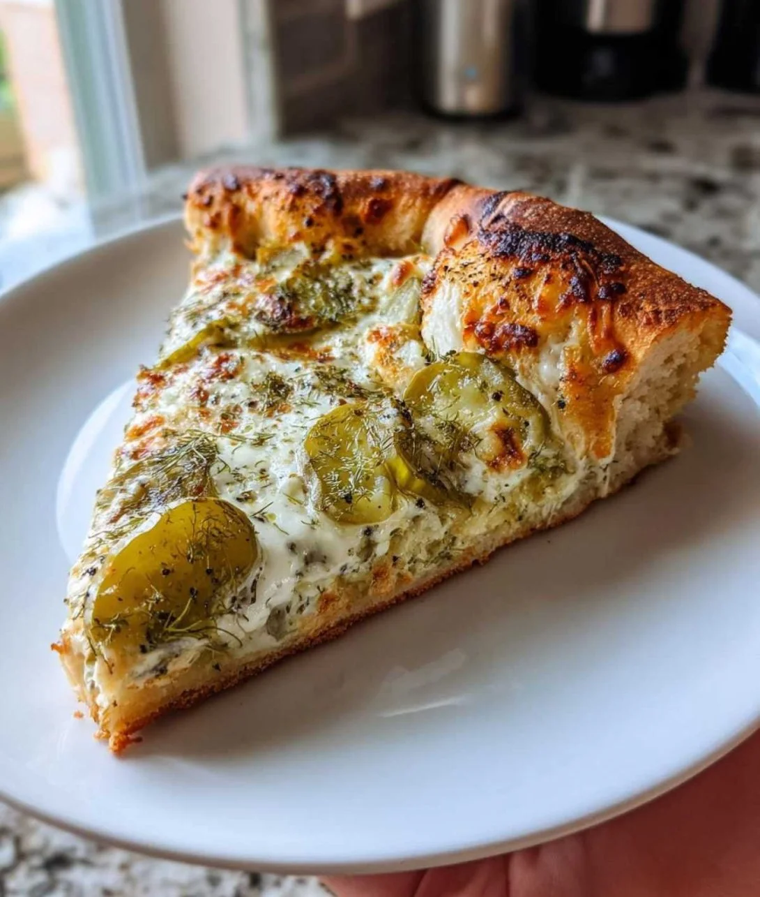 Slice of Epic Dill Pickle Pizza topped with crunchy pickles and cheese
