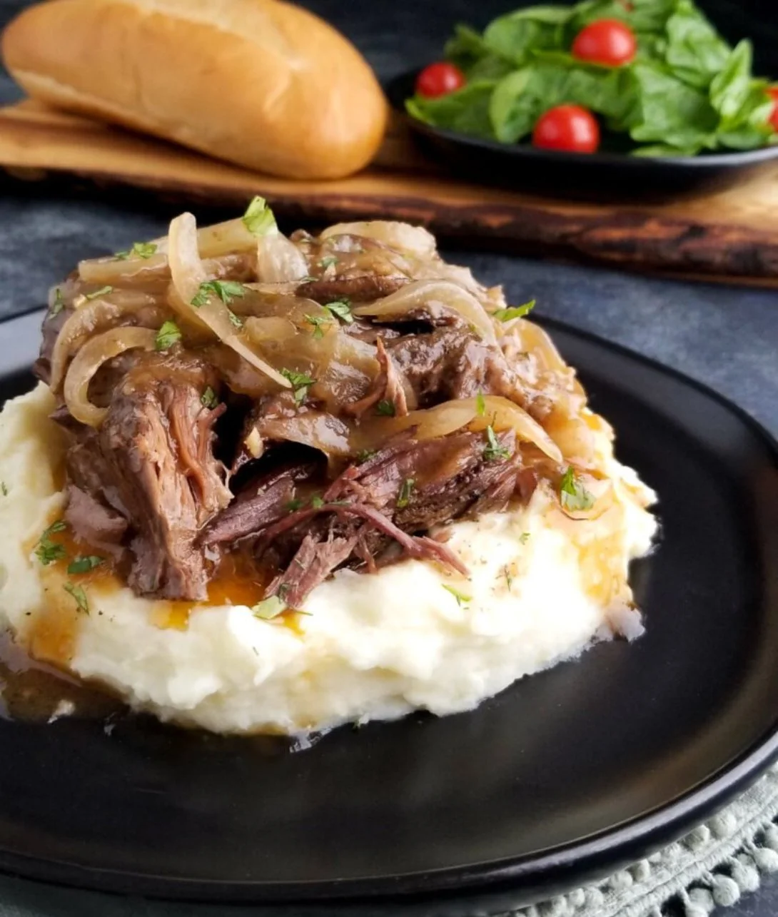 Delicious French Onion Pot Roast served with melted cheese and fresh herbs