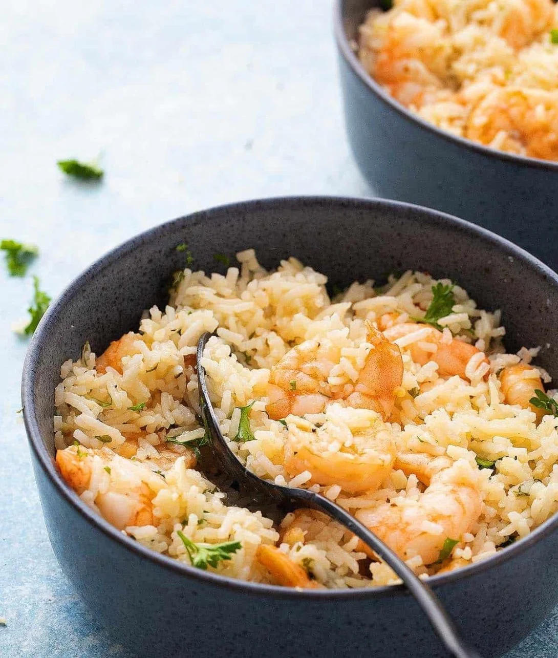 Delicious garlic butter shrimp served over rice with herbs and spices.