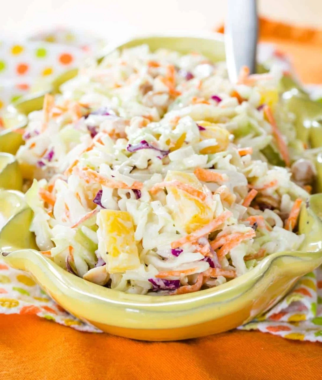 Bowl of Hawaiian Coleslaw with pineapple and cabbage on a wooden table