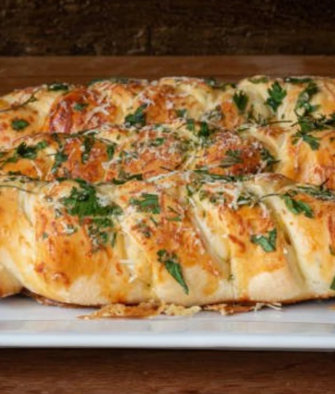 Mozzarella stuffed rosemary parmesan soft pretzels on a wooden board