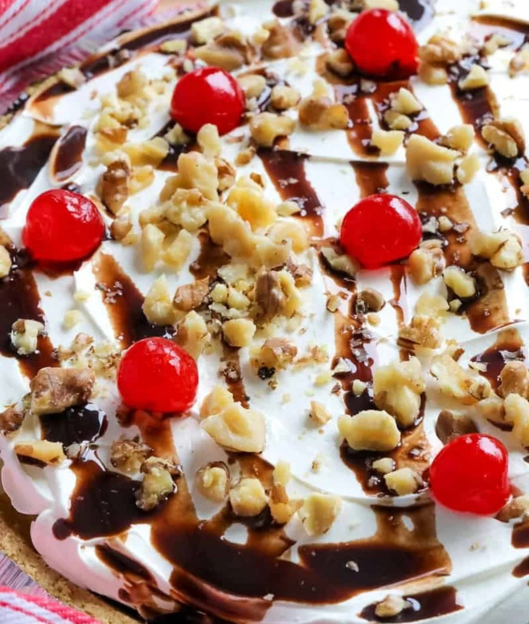 No-bake banana split pie with whipped cream and fresh fruit toppings.