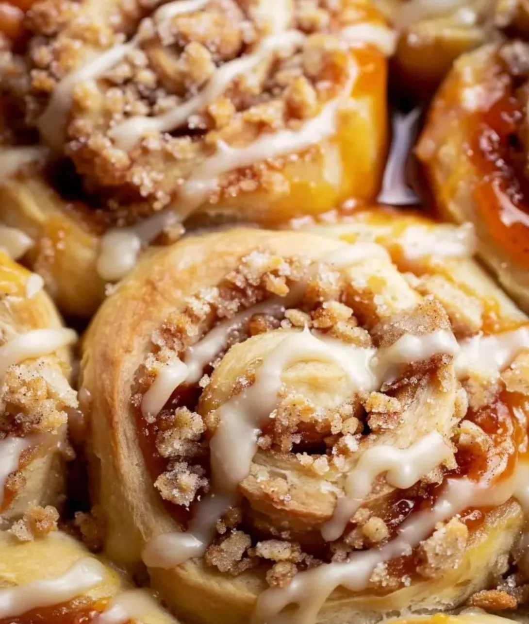 Delicious Peach Cobbler Cinnamon Rolls topped with crumb for a sweet treat.