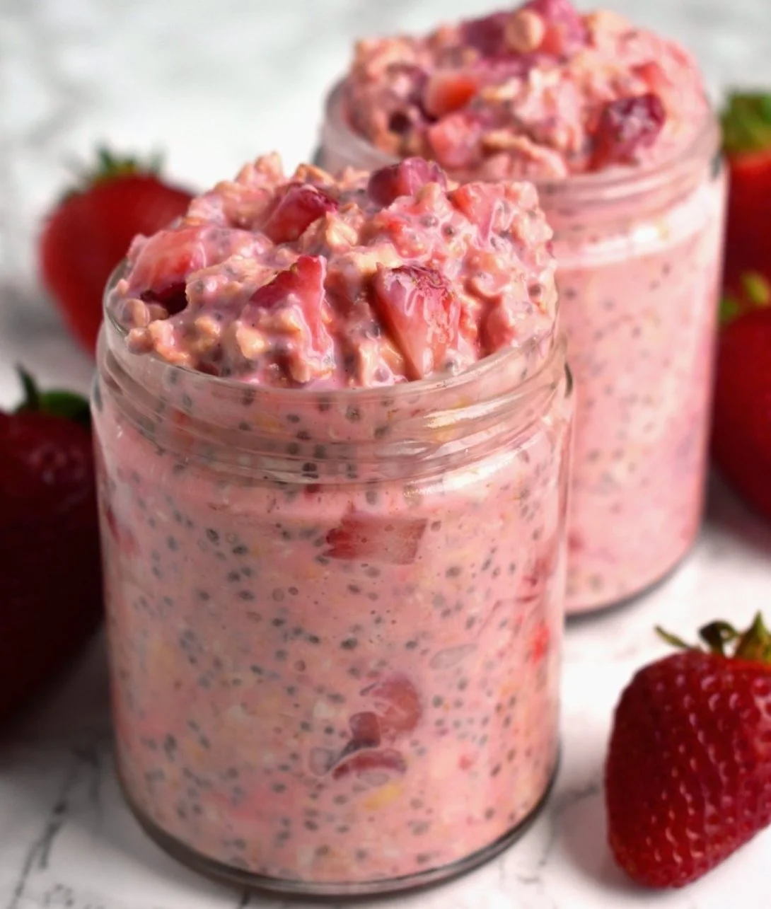 Bowl of strawberries and cream overnight oats topped with fresh strawberries