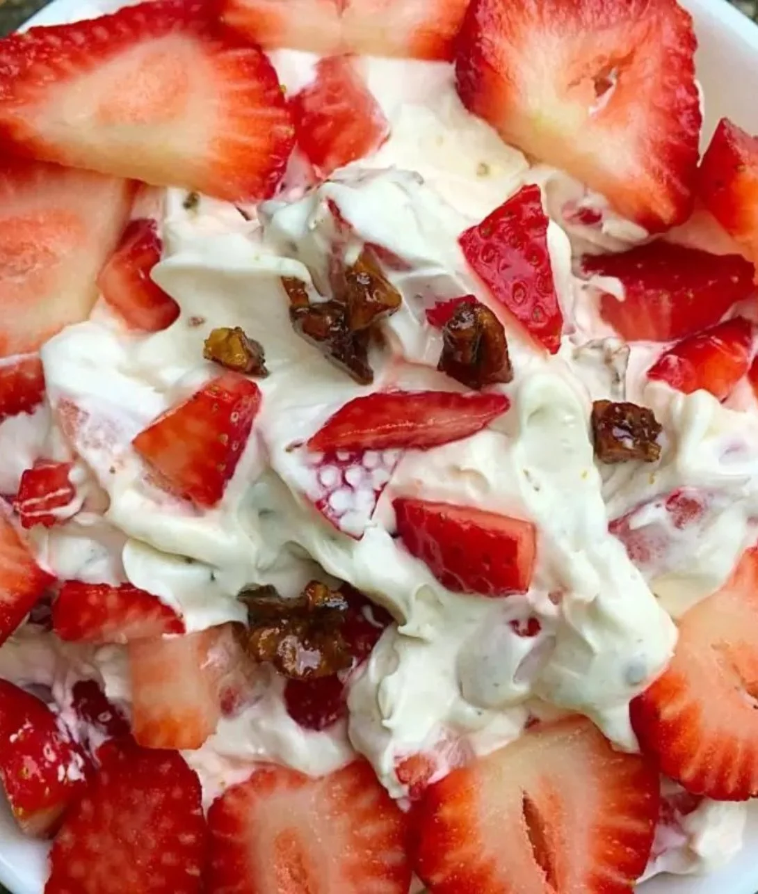 A delicious bowl of Strawberry Crack Salad with fresh strawberries and creamy toppings.