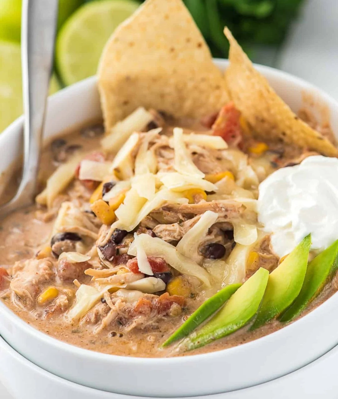 Bowl of creamy White Chicken Chili topped with herbs and served with tortilla chips.